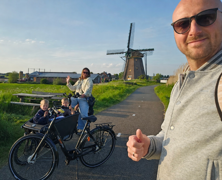 Cycling with the family in the Dutch countryside with windmill
