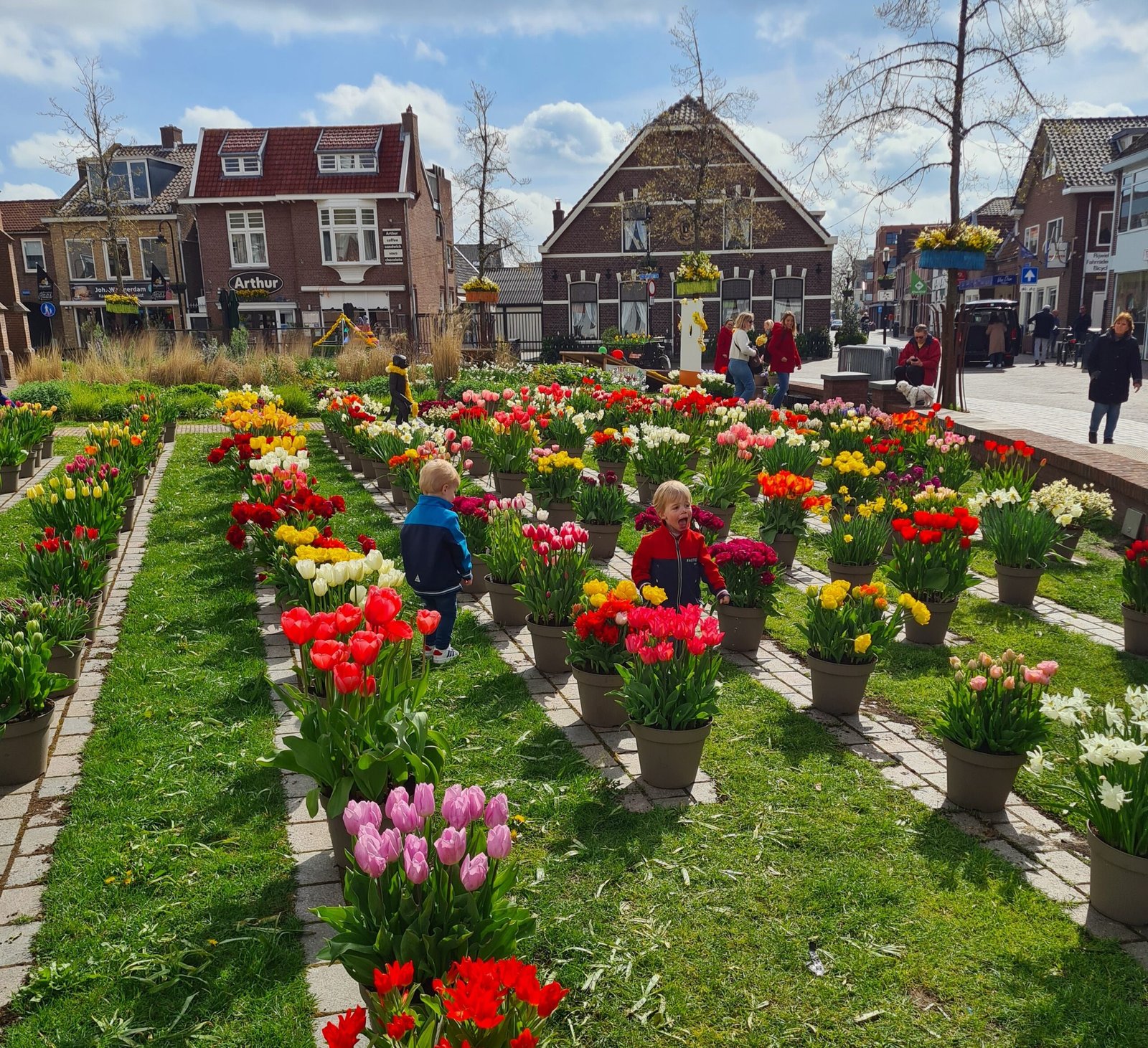 Twins exploring tulip displays in the village square of Noordwijkerhout during Bloemenmozaïeken 2023